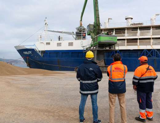 Operarios en puerto descargando maquinaria Operarios en puerto descargando maquinaria